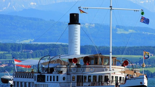 vor dem Hintergrund der Alpen, Schiff untewr österreichischer Flagge auf dem Bodensee