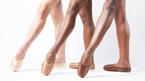 Beine von Tänzerinnen in verschienenfarbenen Spitzenschuhen