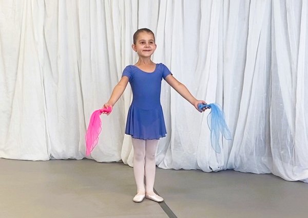 Ballettkind im blauen Kleid. In jeder Hand ein Tuch
